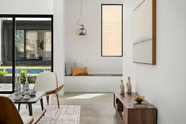 sitting room with baseboards and concrete floors