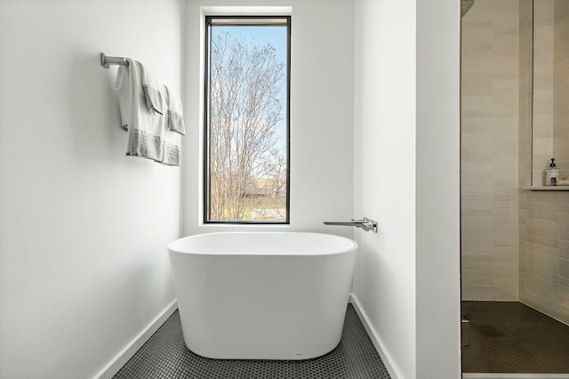 bathroom with tile patterned flooring, a freestanding tub, and a stall shower