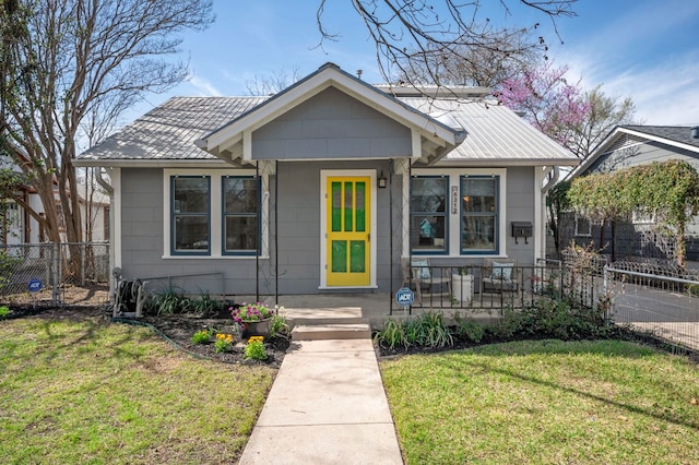 bungalow with a front lawn and fence