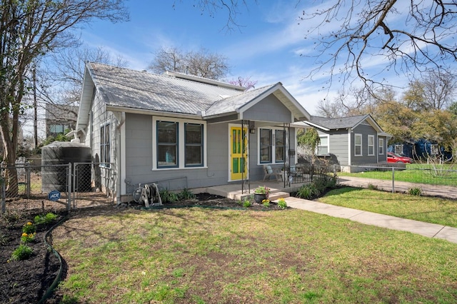 bungalow-style home featuring a gate, covered porch, a front yard, and fence