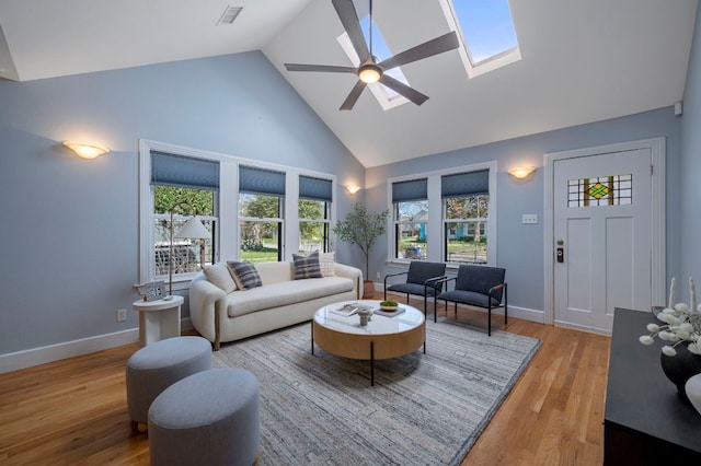 living room with visible vents, a skylight, wood finished floors, high vaulted ceiling, and a ceiling fan