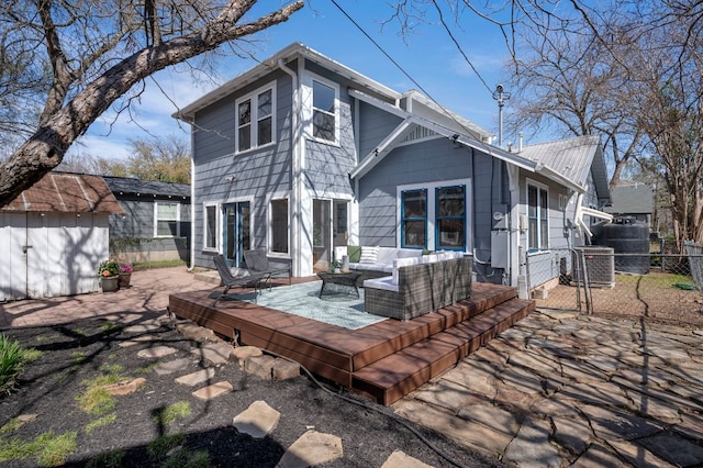 back of house with an outbuilding, a deck, a gate, fence, and outdoor lounge area