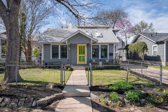 bungalow-style house with a fenced front yard, a front lawn, and a gate