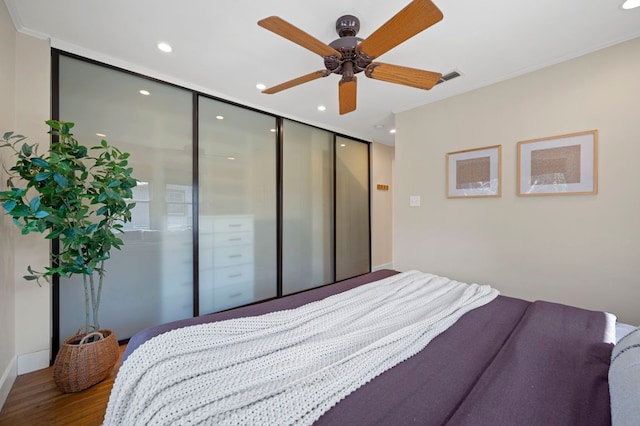 bedroom featuring recessed lighting, wood finished floors, visible vents, and a closet