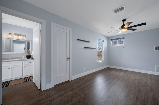 interior space featuring visible vents, baseboards, ceiling fan, and dark wood-style flooring