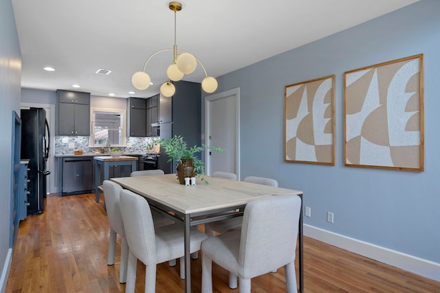 dining room featuring visible vents, recessed lighting, baseboards, and wood finished floors