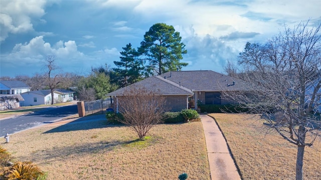 view of front of home featuring brick siding, a front yard, and fence