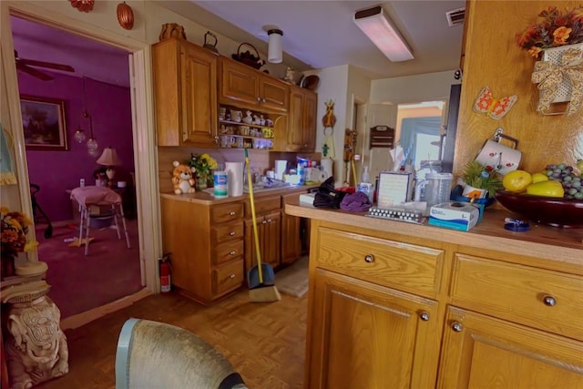 kitchen featuring visible vents, brown cabinets, and light countertops