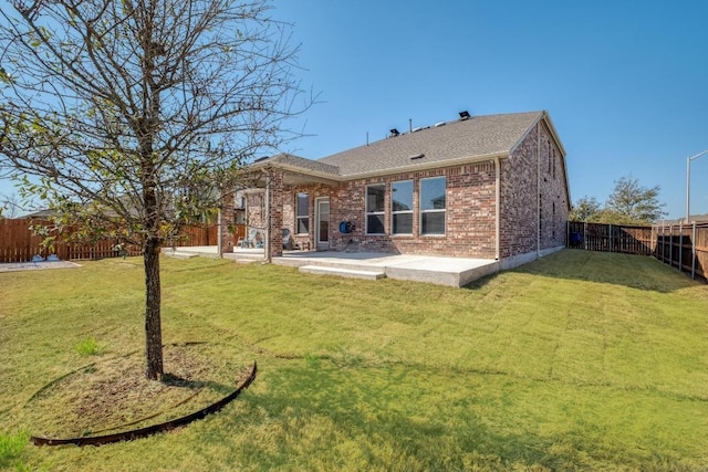 back of house featuring a patio, brick siding, a fenced backyard, and a lawn