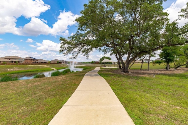 view of property's community with a yard, a water view, and a residential view