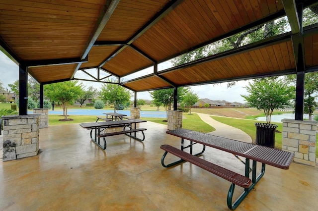 view of property's community featuring a gazebo, a patio, and a lawn