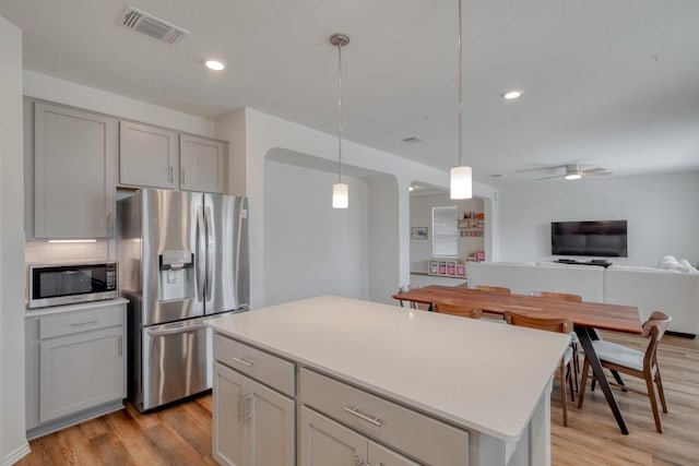 1004 Brenham Ln, Leander, TX 78641 - kitchen with appliances with stainless steel finishes, light wood-style flooring, recessed lighting, open floor plan, and backsplash
