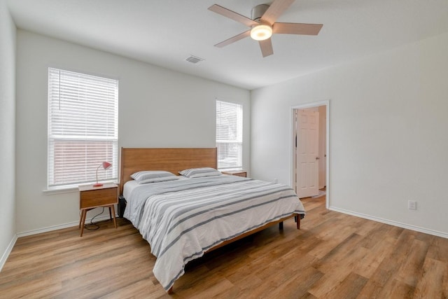 bedroom with visible vents, baseboards, ceiling fan, and light wood finished floors