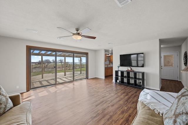 living room with dark wood finished floors, baseboards, visible vents, and ceiling fan