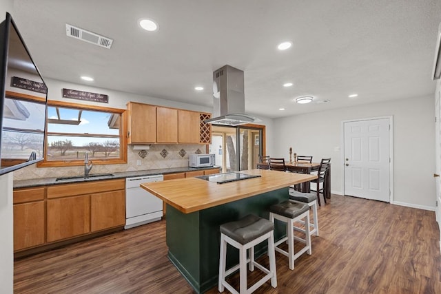 kitchen with white appliances, visible vents, a sink, wood counters, and island range hood