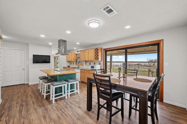 dining space with dark wood finished floors, visible vents, recessed lighting, and baseboards