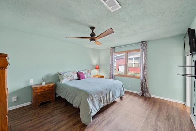 bedroom with visible vents, a ceiling fan, a textured ceiling, wood finished floors, and baseboards