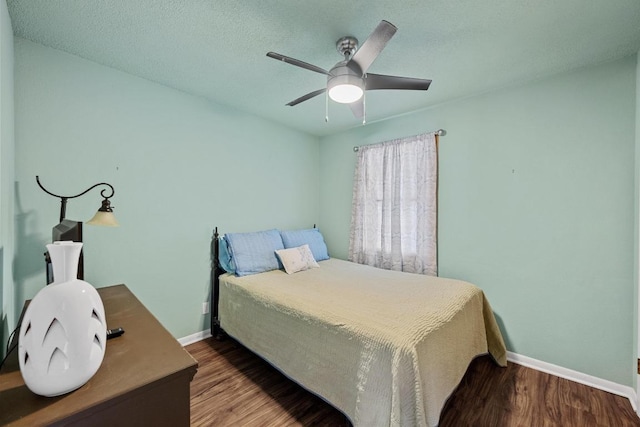 bedroom featuring a textured ceiling, a ceiling fan, baseboards, and wood finished floors