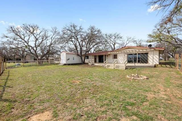 rear view of property with a yard, an outdoor structure, a fenced backyard, and a patio area