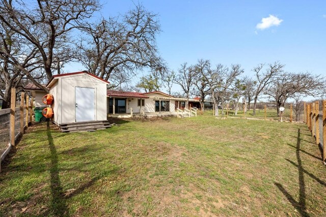 view of yard featuring an outdoor structure, a storage shed, and a fenced backyard