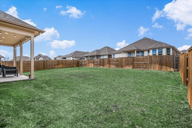 view of yard featuring a patio, a fenced backyard, and a residential view