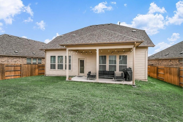 back of property with a yard, a patio, a fenced backyard, and roof with shingles