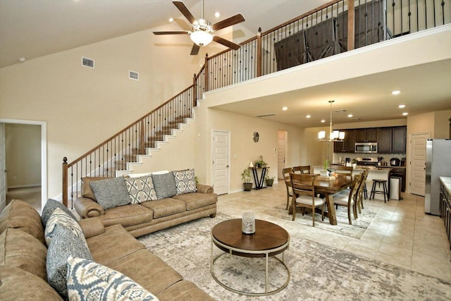 living room with stairway, recessed lighting, ceiling fan with notable chandelier, and visible vents