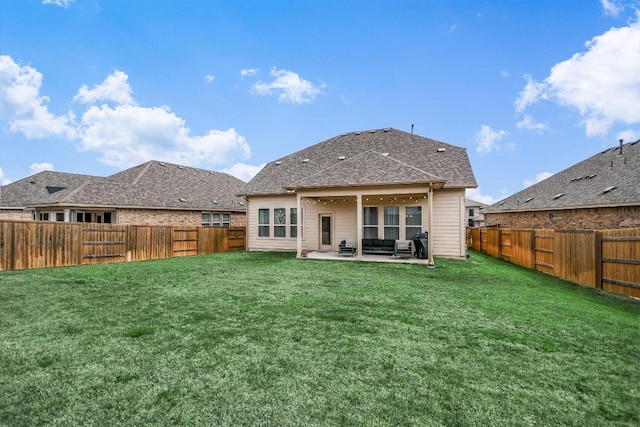 rear view of house featuring a patio area, a lawn, and a fenced backyard