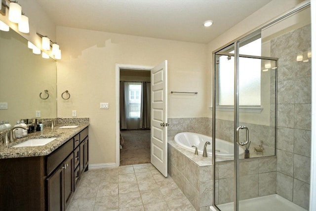 full bathroom with a shower stall, a bath, tile patterned floors, and a sink