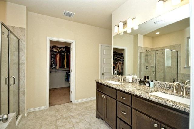 full bathroom featuring a sink, visible vents, a stall shower, and double vanity