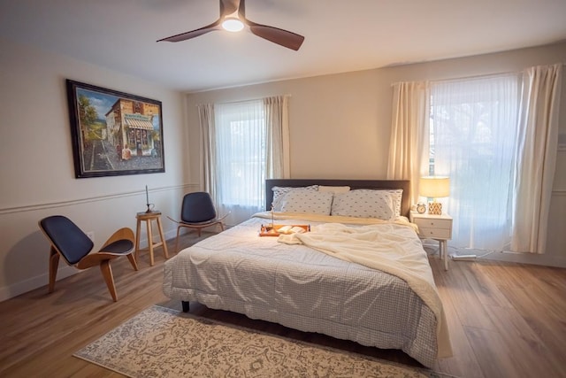bedroom featuring wood finished floors, a ceiling fan, and baseboards