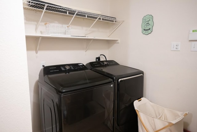 clothes washing area with washer and clothes dryer and laundry area