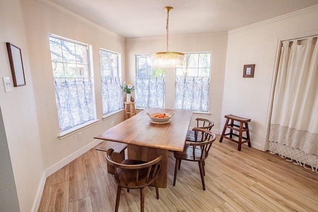 dining room featuring plenty of natural light, baseboards, ornamental molding, and a chandelier