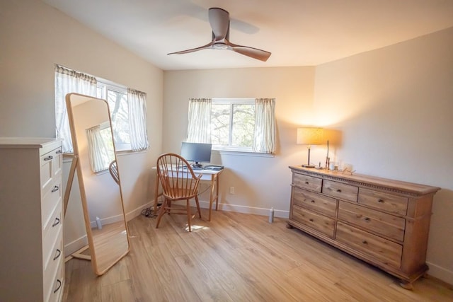living area featuring a ceiling fan, light wood finished floors, and baseboards