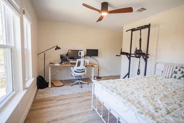 bedroom featuring visible vents, wood finished floors, baseboards, and ceiling fan