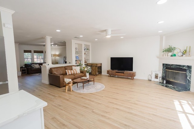 living room with light wood-type flooring, decorative columns, recessed lighting, a fireplace, and ceiling fan