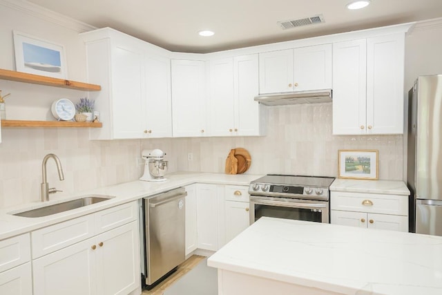 kitchen with stainless steel appliances, a sink, under cabinet range hood, light stone counters, and white cabinetry