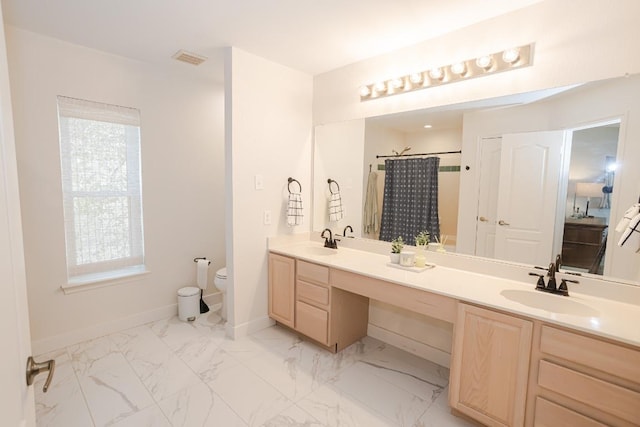full bath featuring toilet, double vanity, baseboards, marble finish floors, and curtained shower