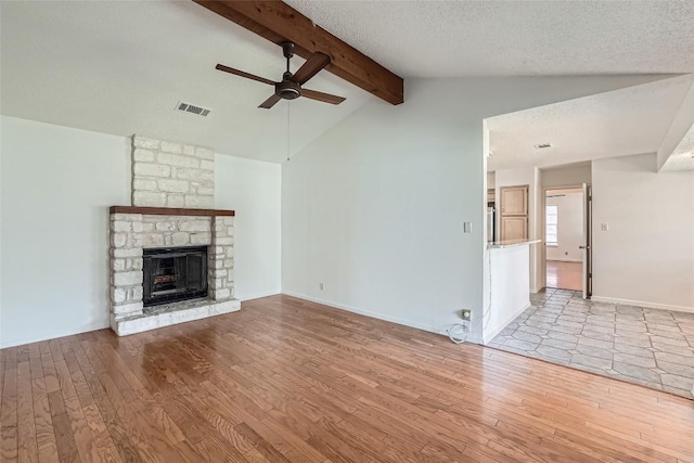 unfurnished living room featuring visible vents, vaulted ceiling with beams, ceiling fan, and wood finished floors