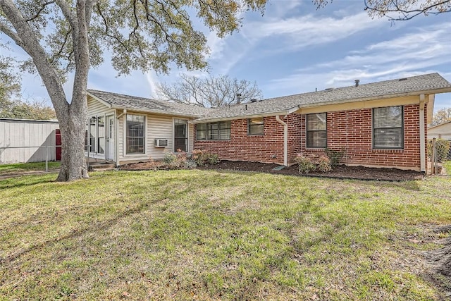 rear view of property with a yard, brick siding, cooling unit, and fence