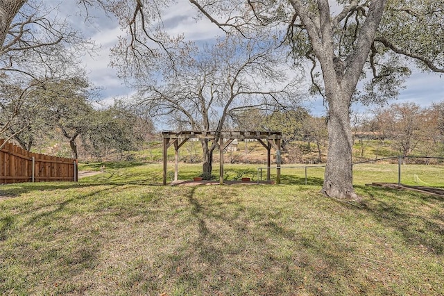 view of yard featuring fence and a pergola