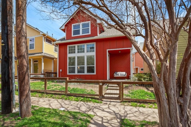 1601 Miriam Ave Unit 103, Austin, TX 78702 - view of front of property with board and batten siding, a fenced front yard, and a shingled roof