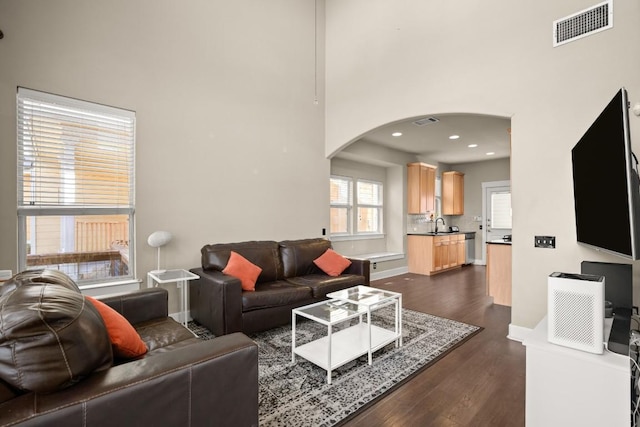 1601 Miriam Ave Unit 103, Austin, TX 78702 - living area featuring arched walkways, a high ceiling, dark wood finished floors, and recessed lighting
