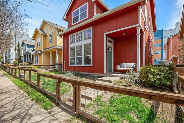 1601 Miriam Ave Unit 103, Austin, TX 78702 - view of front of property featuring board and batten siding, a fenced front yard, a residential view, and a gate