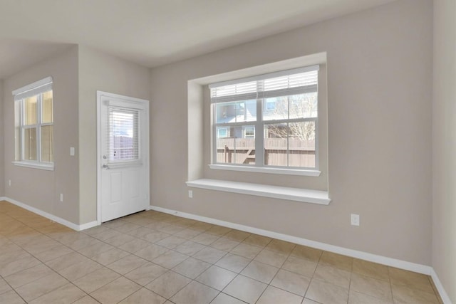 foyer entrance featuring light tile patterned floors and baseboards