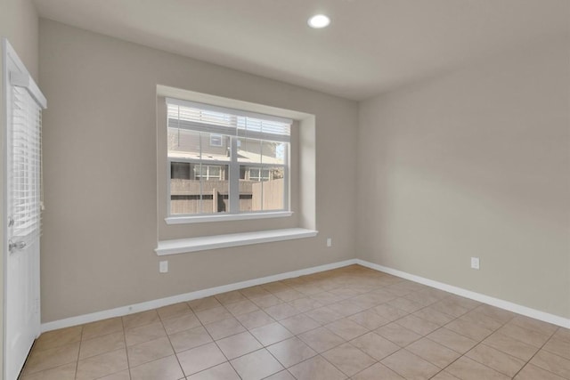 spare room featuring light tile patterned floors, recessed lighting, and baseboards