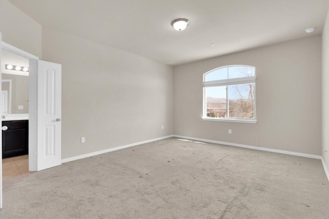 empty room with light colored carpet and baseboards