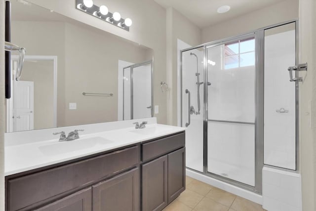 bathroom with a sink, a stall shower, double vanity, and tile patterned flooring