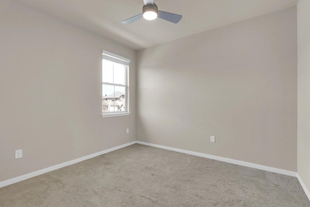 carpeted empty room featuring baseboards and ceiling fan