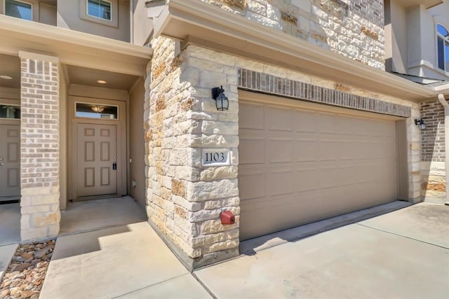 entrance to property with an attached garage and stone siding